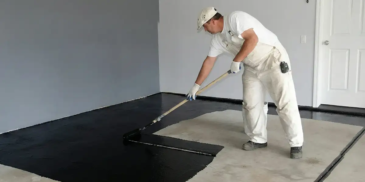 basement waterproofing professional applying waterproof coating to protect a basement floor in Raleigh, NC